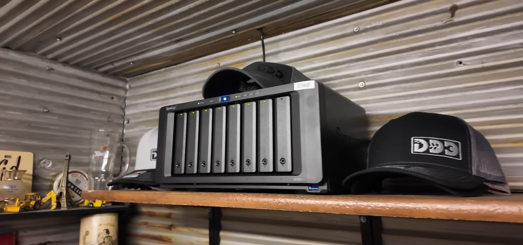 Synology DS1821+ installed on a shelf in Neil's shop, all drive bays populated with green lights