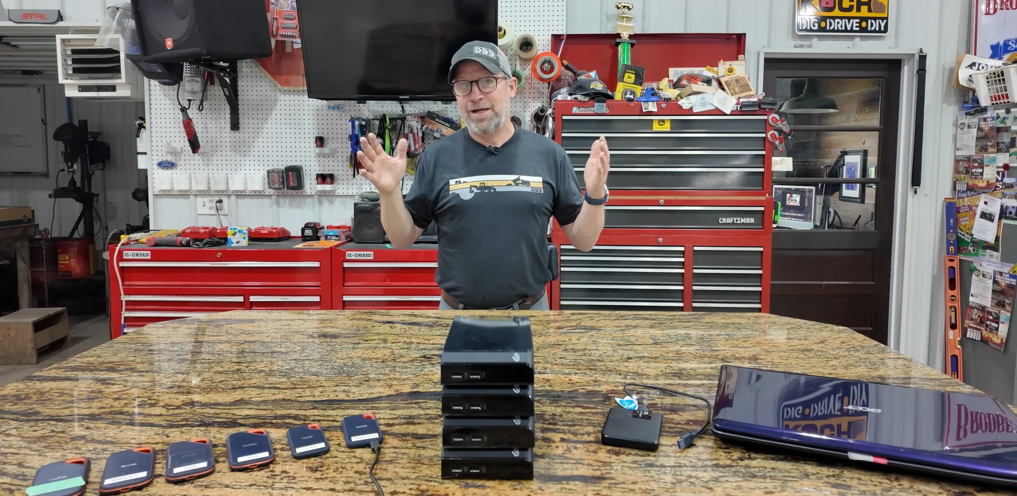 Neil Koch showing his collection of portable hard drives on the shop workbench